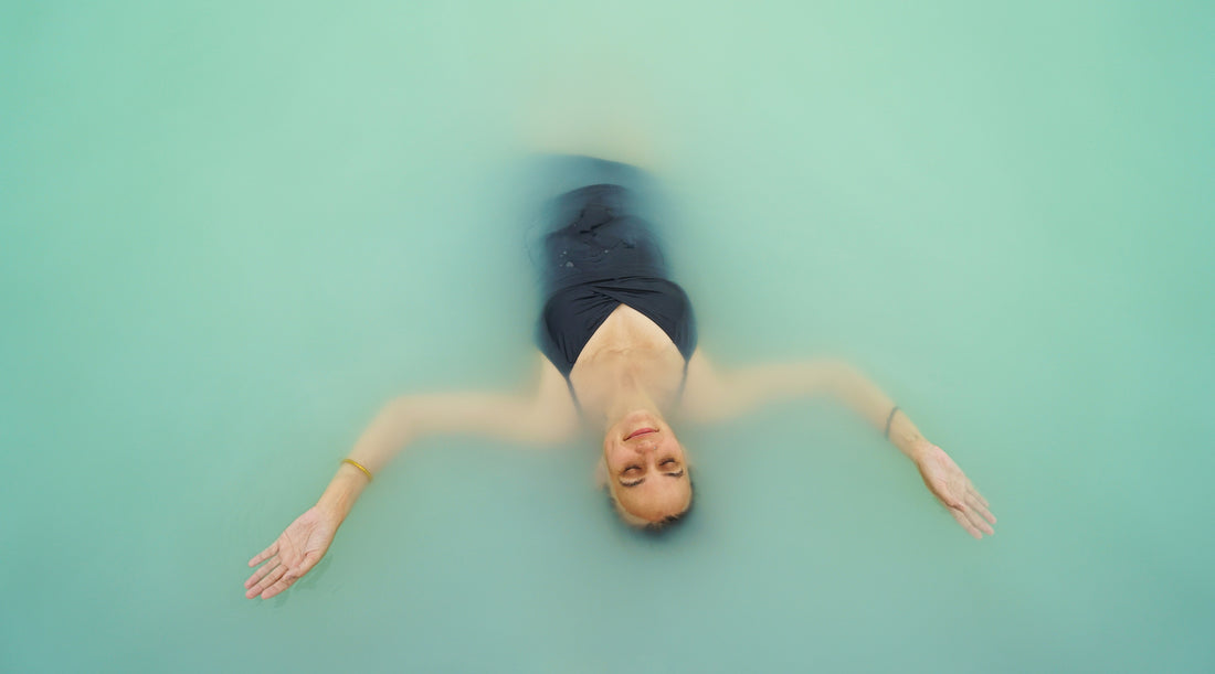WOMAN FLOATING IN WATER ENJOYING THE MAGIC OF ICELAND