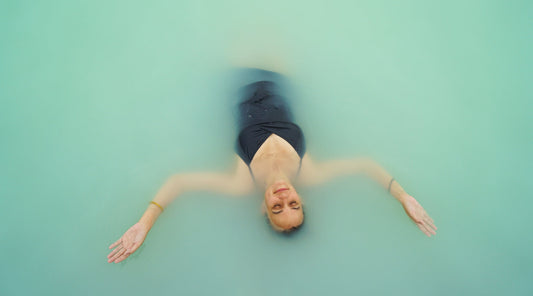 WOMAN FLOATING IN WATER ENJOYING THE MAGIC OF ICELAND